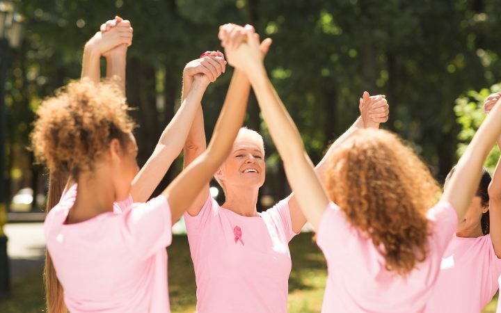 breast-cancer-survivors-standing-holding-hands-in-LWHN83G