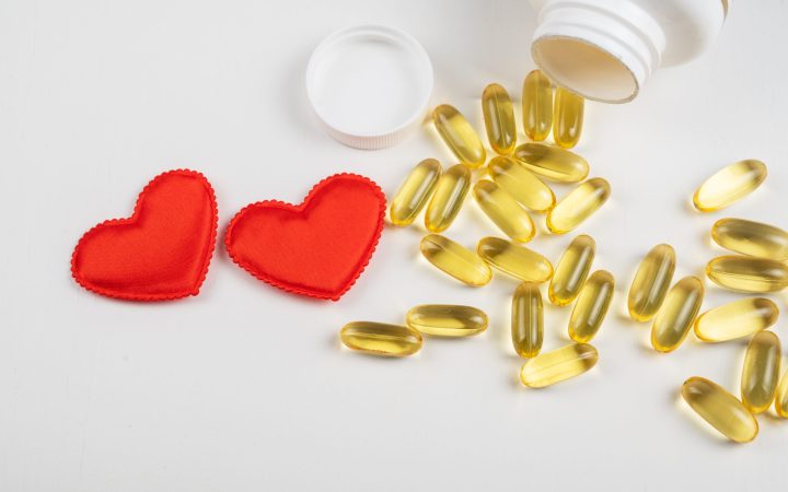 gold-fish-oil-isolated-white-background-with-red-hearts-pile-fish-oil-with-omega-acid-concept