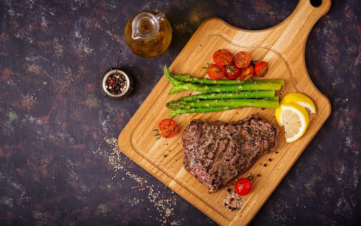 juicy-steak-rare-beef-with-spices-on-a-wooden-PP7FEYV