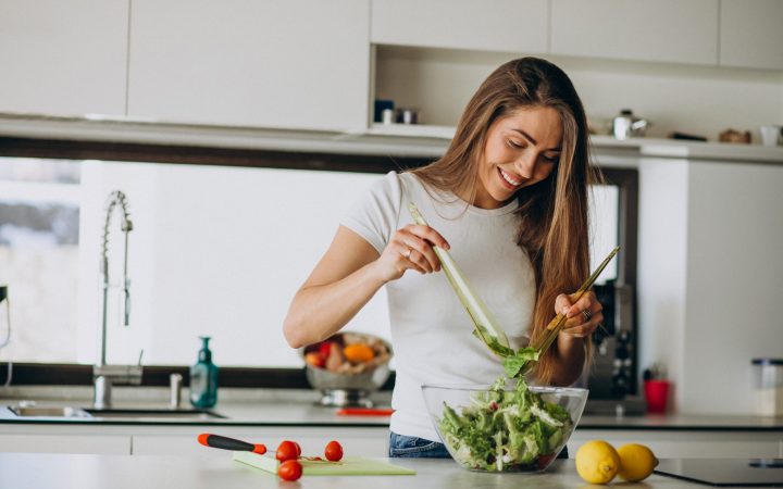 young-woman-making-salad-kitchen